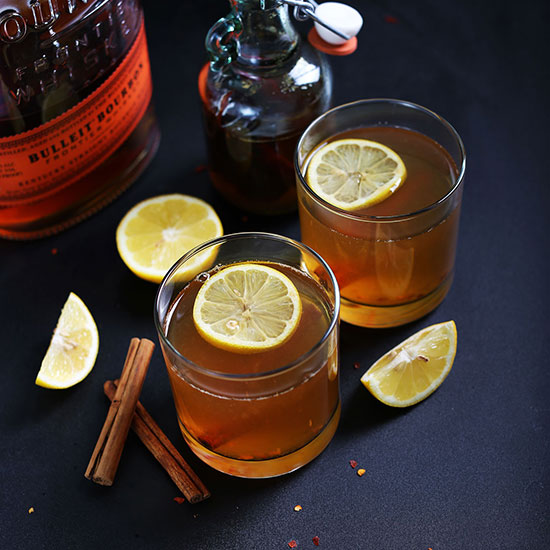 Two glasses of our Chili Cinnamon Hot Toddy recipe topped with lemon slices