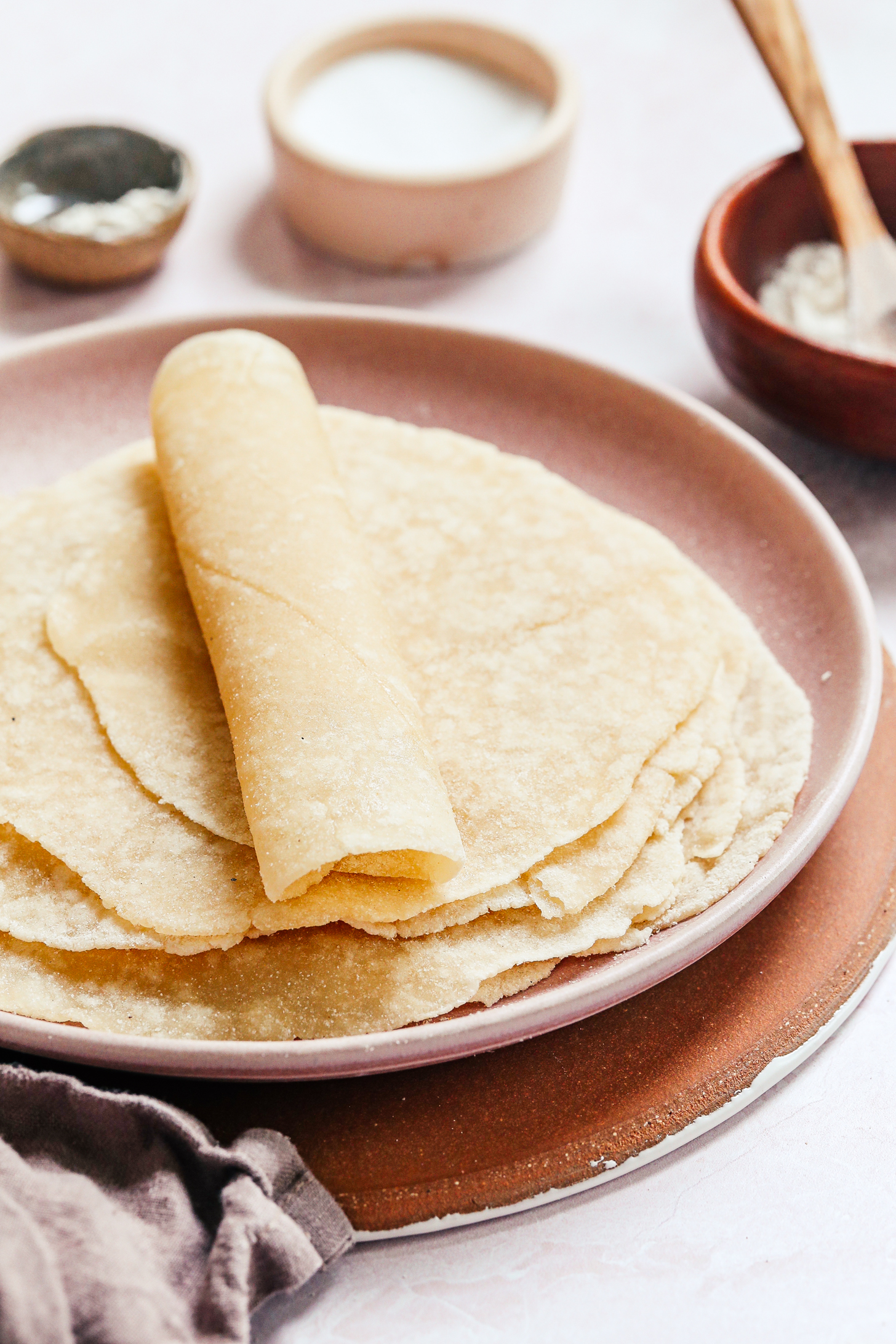 Rolled up cassava flour tortilla on a plate with more tortillas under it