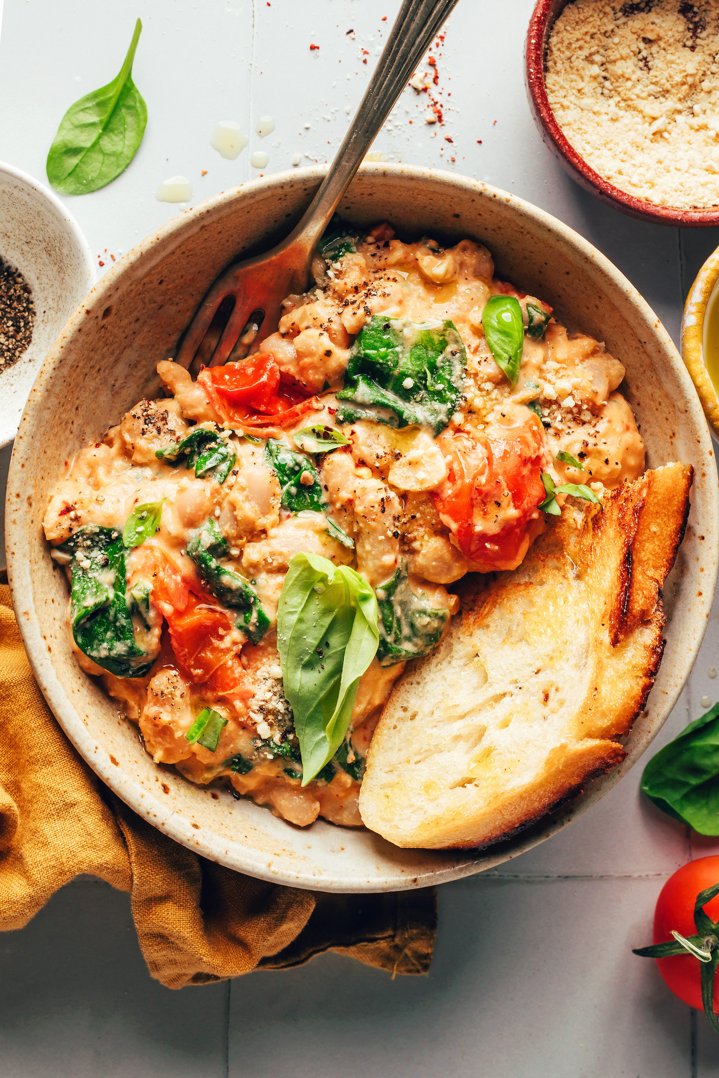 Toasted bread in a bowl with Italian white beans with cherry tomatoes and basil