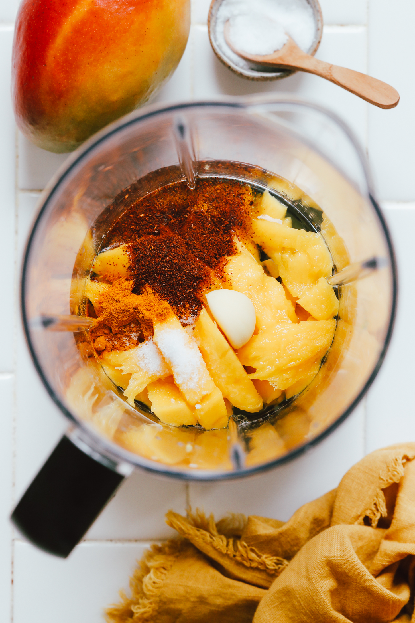 Blender with mango, garlic, salt, chili powder, and lime juice