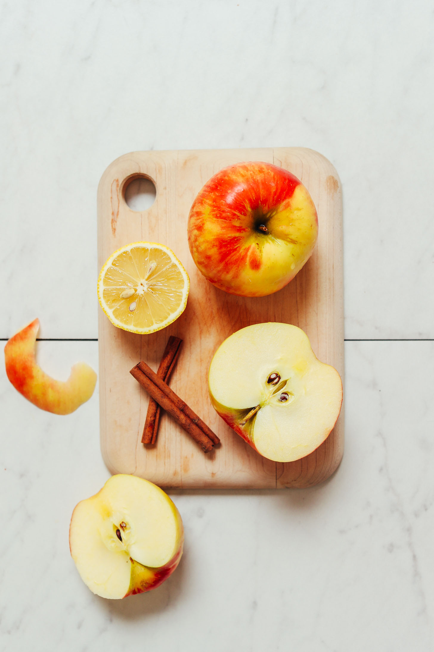 Cutting board with apples, lemon, and cinnamon sticks
