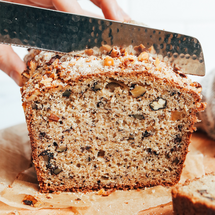Close up shot of a knife slicing into gluten-free dairy-free banana bread