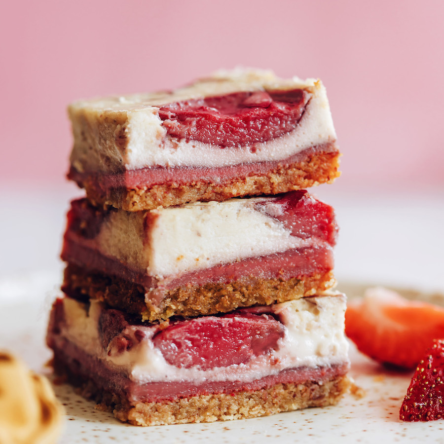 Stack of strawberry cheesecake bars on a plate