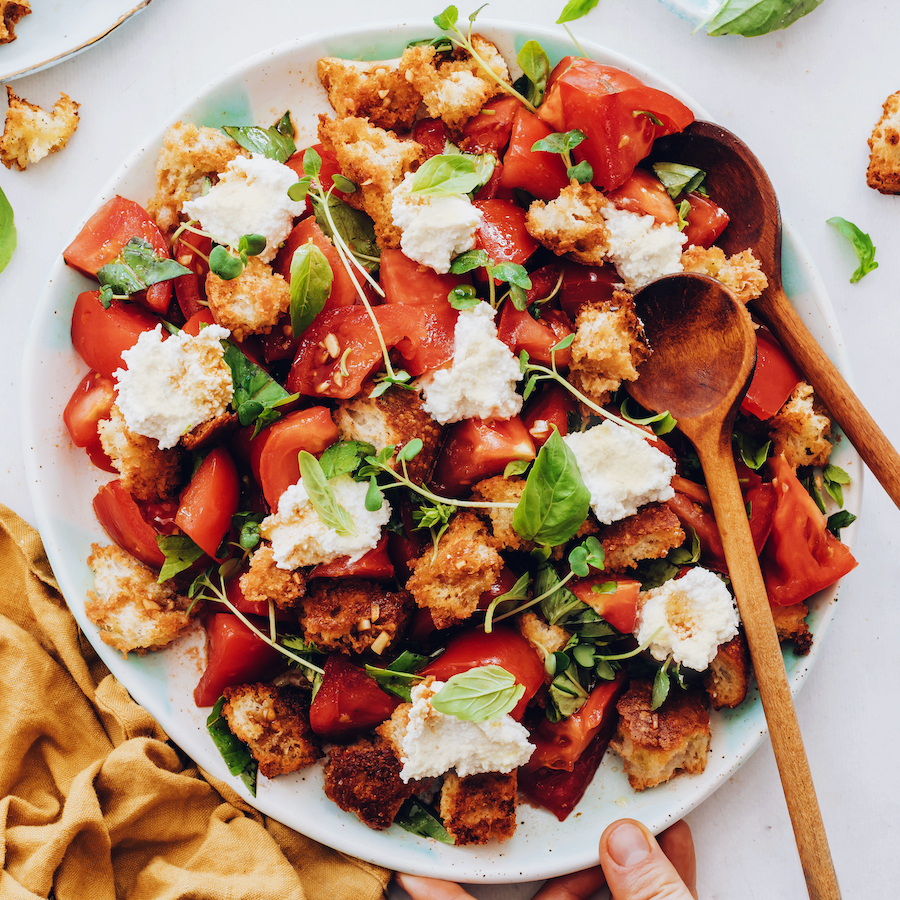 Wooden spoon on a platter of our heirloom tomato panzanella recipe