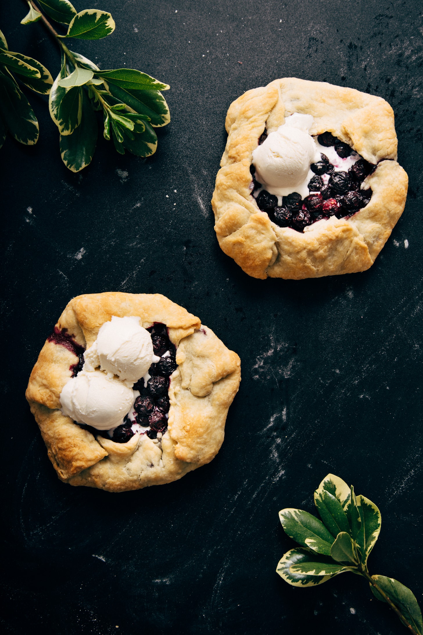 Two vegan Mini Blueberry Galettes topped with scoops of ice cream