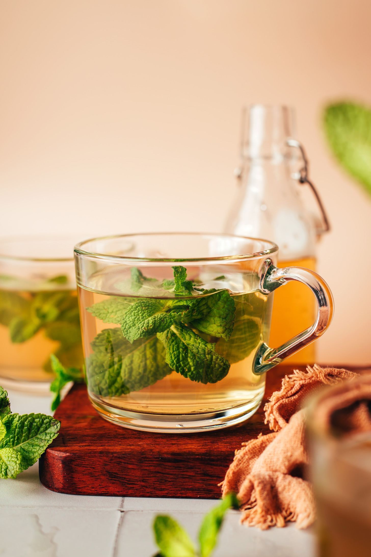 Clear glass mugs of fresh mint tea with mint leaves in them