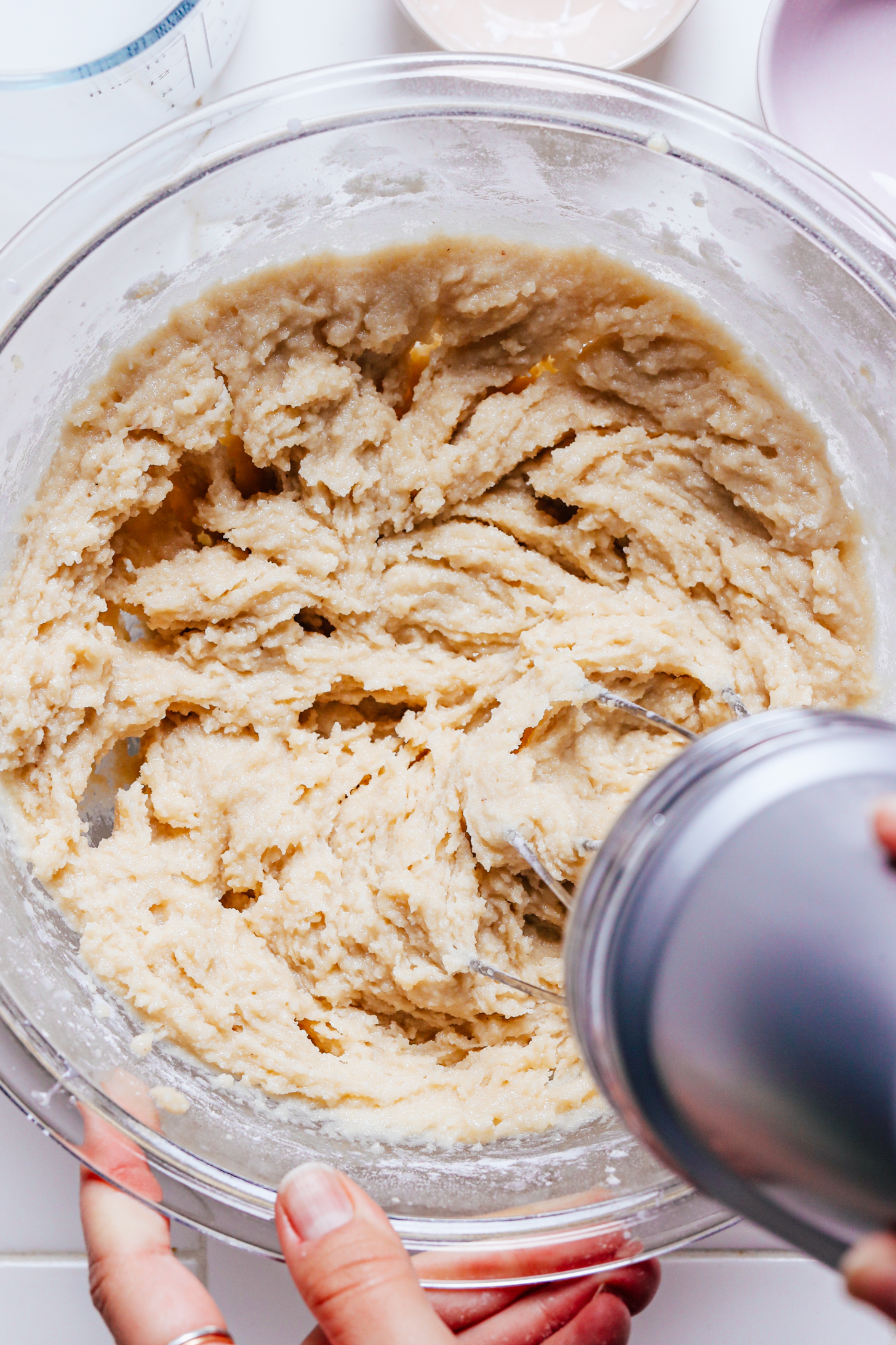 Using an electric mixer to combine the almond cake batter