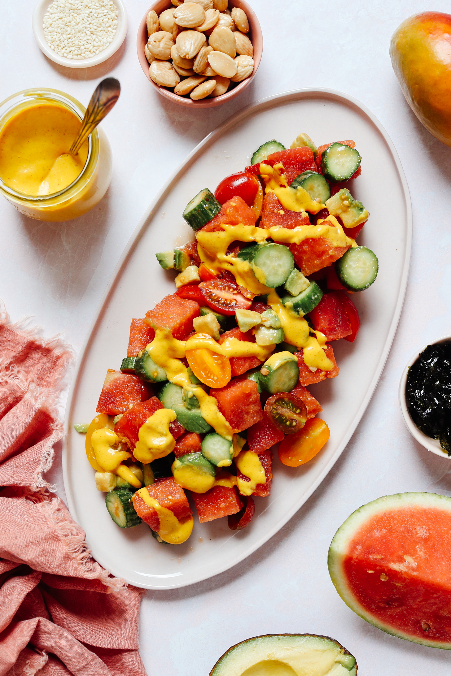 Platter of watermelon, cucumber, and tomatoes drizzled with spicy mango vinaigrette