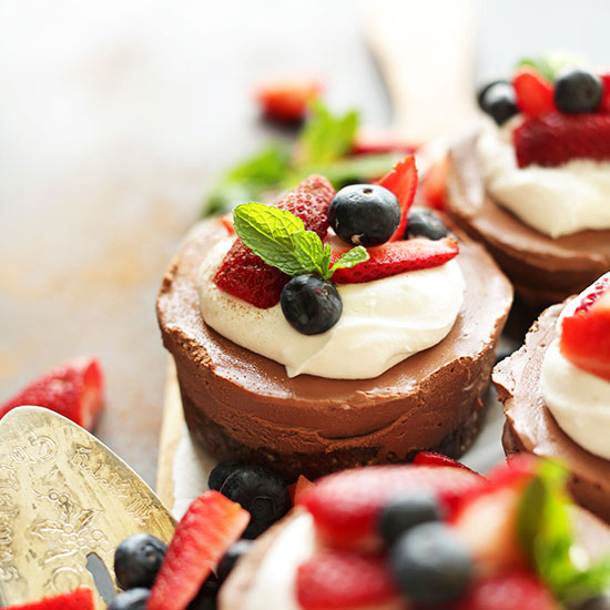 Platter of Mini Vegan No-Bake Chocolate Cheesecakes topped with fresh berries