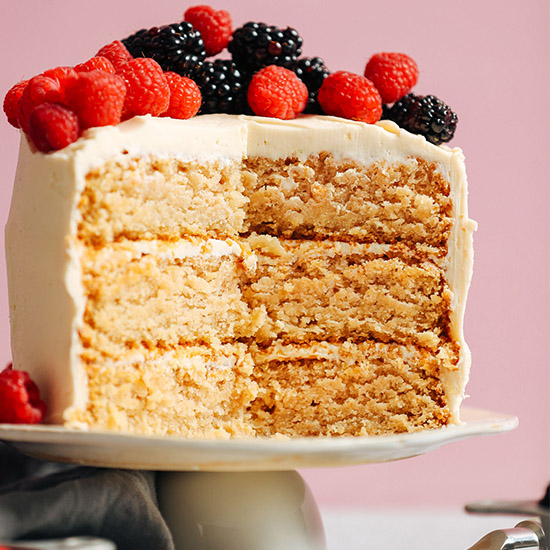 Three layer Vegan Gluten-Free Vanilla Cake topped with fresh raspberries and blackberries
